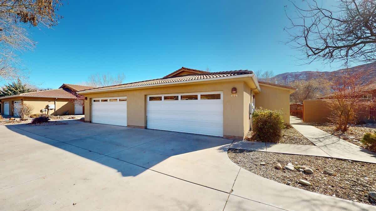 A single-story house with a garage, a driveway, and a landscaped garden.