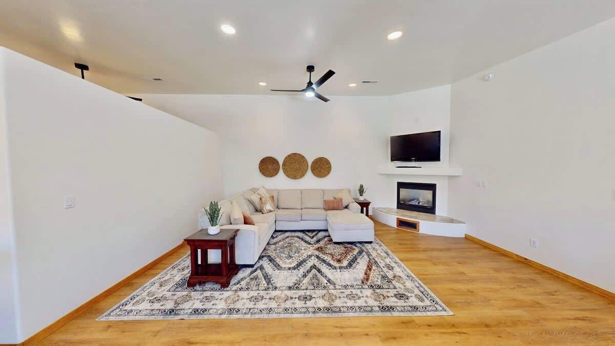 A modern living room with a sofa, a TV, and a fireplace.