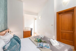 Une chambre d’hôtel avec un lit, une armoire en bois, un bureau et une fenêtre.