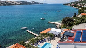 A coastal hotel with a swimming pool, sun loungers, and a view of the sea. - Family Resort Santa Maria I Apartment 7, Stara Novalja, Croatia (Stara Novalja)