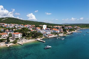 Une ville côtière avec des bâtiments, un port de plaisance et des eaux d’un bleu limpide.