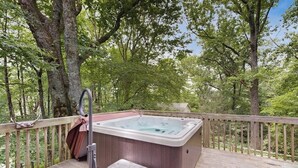 A hot tub on a wooden deck surrounded by trees. - Charming dog-friendly cottage near Blowing Rock with private hot tub, deck, BBQ (Blowing Rock)