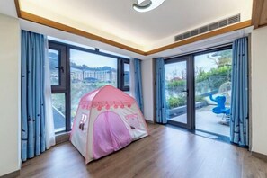 A room with a large window, a pink tent-like structure, and a blue chair. - Fangtingshu Hostel (Zhangjiajie)