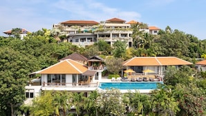 A resort with multiple buildings, a swimming pool, and lush greenery.