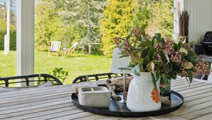 A wooden table with a white vase and a black tray containing a candle and a small object.