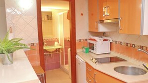 A compact kitchen with a sink, a microwave, and a dishwasher.