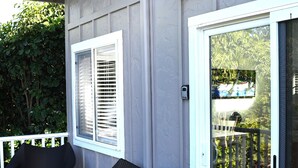 A porch with wicker furniture and a sliding glass door.