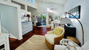 A spacious living area with a sofa, a dining table, and a kitchen in the background.