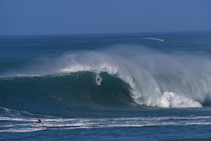 Eine große Welle im Meer, auf der Surfer reiten.