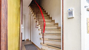 Eine Treppe mit roter Handlauf, der zu einer Tür führt.
