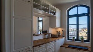 Una cocina con armarios blancos, encimera de madera, un banco empotrado y un ventanal con vistas.