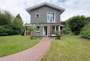 A two-story house with a brick pathway leading to the front door. - Holiday Home "Zwischen Den Seen" with Private Terraces, Garden and Wi-Fi (Wiefelstede-Dringenburg)