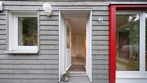 A house with a number '41' on the door, a welcome mat, and a small step leading to the entrance.