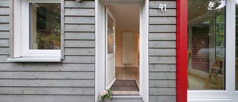 A house with a number '41' on the door, a welcome mat, and a small step leading to the entrance.
