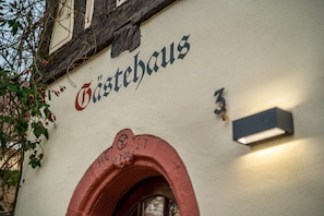 A building facade with the inscription 'Gastehaus' and a door marked '706 St.'