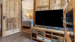 A room with a wooden TV stand, a bed, and a door leading to another room. - Weissburgunder Superior Apartment 52 sqm, City View, up to 4 Guests, Optional Breakfast, 3D Tour (Vogtsburg)