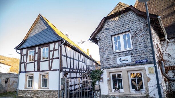 A traditional half-timbered building with a stone facade, a visible entrance gate, and a street sign indicating 'Schafwinkel.' - Holiday Apartment "4" with Mountain View, Shared Garden & Wi-Fi (Wallhausen)