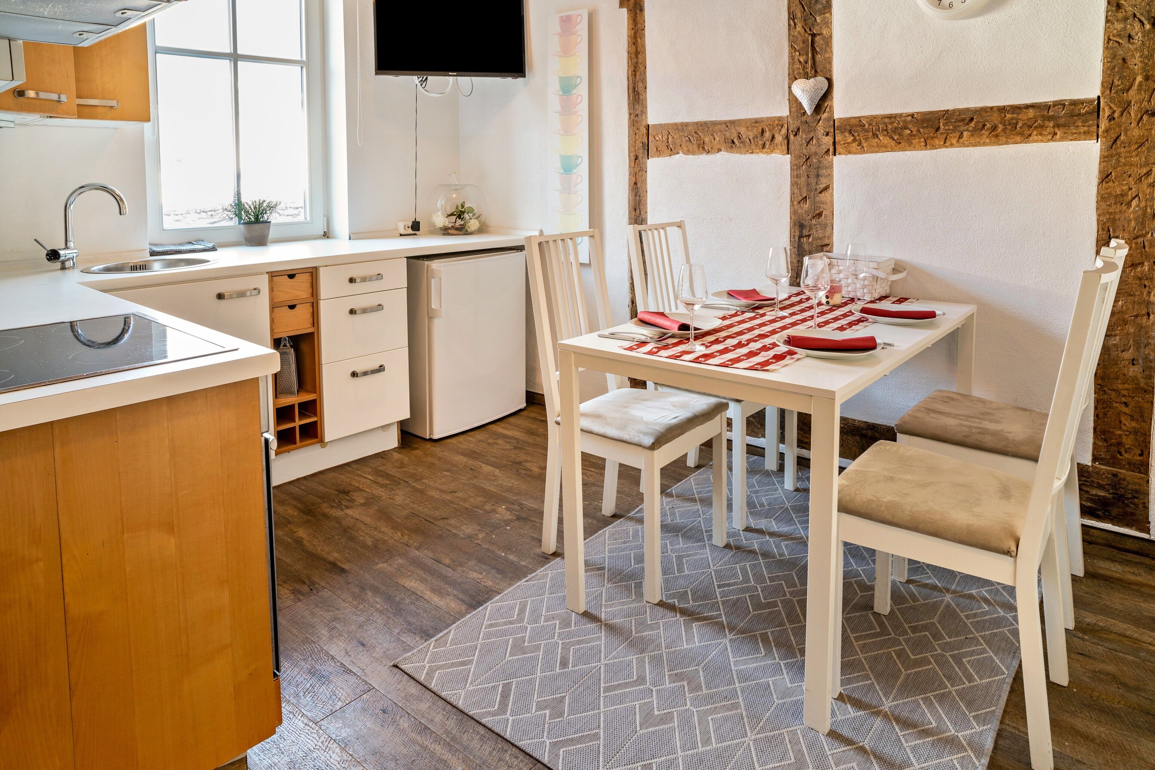 Una cocina moderna con comedor, suelo de madera y un ventanal grande.