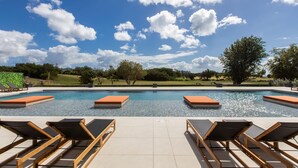 A swimming pool with lounge chairs and a view of the sky. - B-505 (Cupecoy)