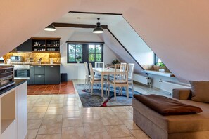 A modern loft with a kitchen, dining area, and living space.
