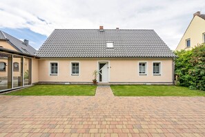 Et toetagers hus med tegltag, en hoveddør og et lille vindue.