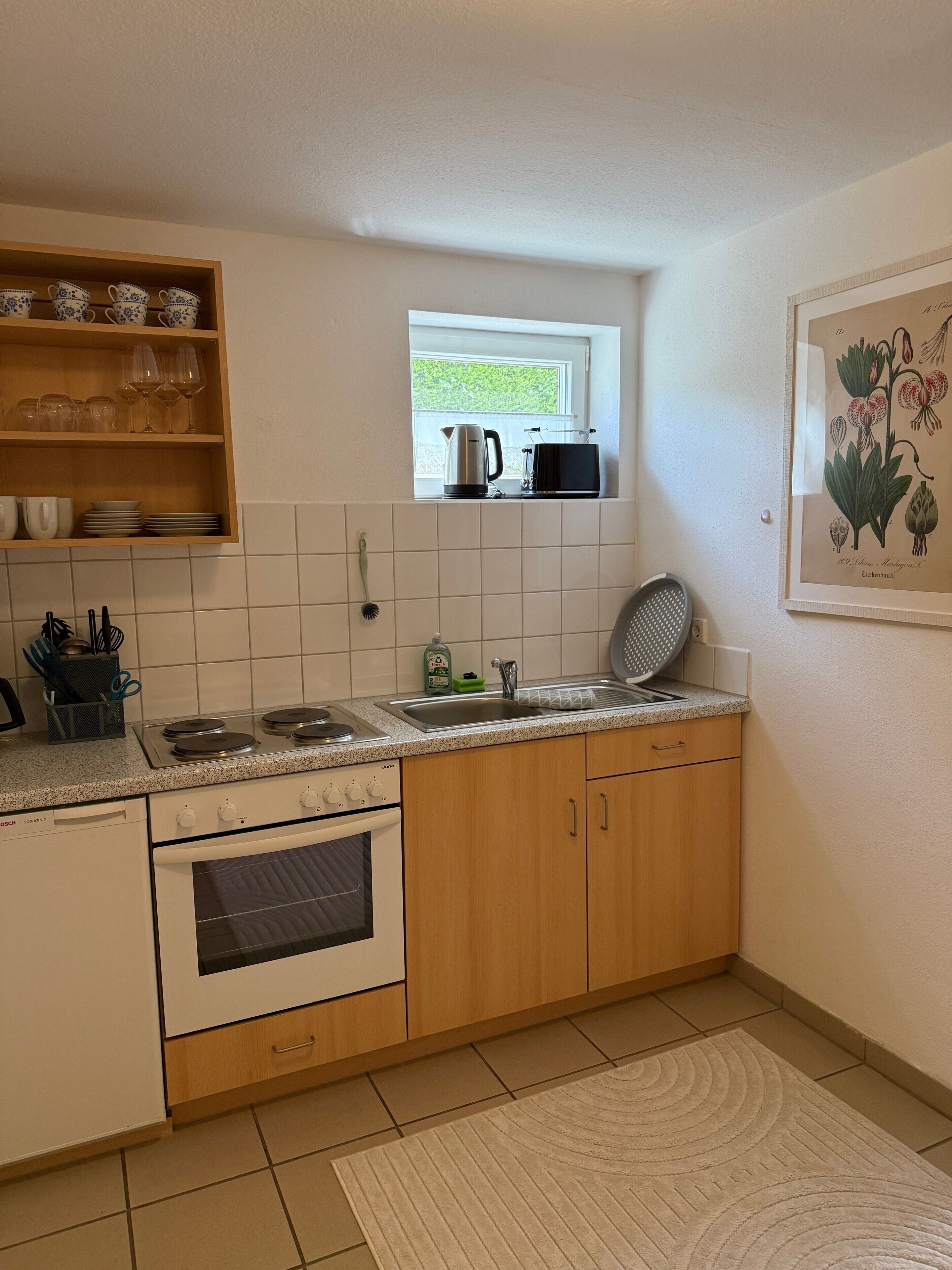 Una cocina con ventana, un lavamanos, una estufa y un lavavajillas.