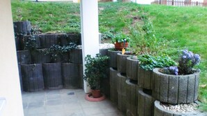 En have med krukker og planter anbragt i en trappeformet stenplanter.