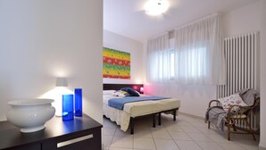 Une chambre à coucher avec un lit, une table de chevet, une lampe et une chaise.