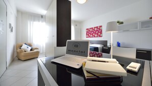 A modern hotel room with a laptop on a desk, a lamp, and a sign indicating it's a B&B apartment. - Mina 1 in Gabicce Mare (Cattolica)