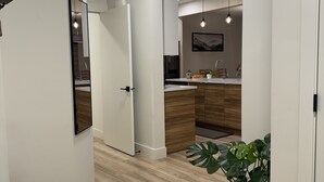 A modern kitchen with wooden cabinets, a central island, and pendant lighting.