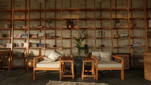 Un salon chaleureux avec des étagères en bois, deux canapés et une table basse.