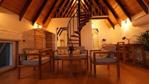 Un salon chaleureux de style industriel, avec des meubles en bois, un escalier en colimaçon et une grande fenêtre.