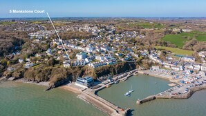 Vue aérienne du 5 Monkstone Court, montrant un emplacement en bord de mer avec un port de plaisance, des immeubles résidentiels et une promenade en bord de mer bien visible.