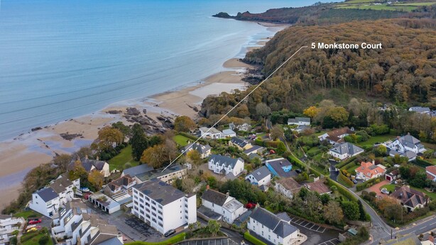 Vue aérienne d’une ville côtière avec une plage, des maisons et une zone identifiée par le nom « 5 Monkstone Court ».