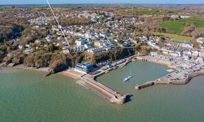 Vue aérienne du 5 Monkstone Court, montrant un emplacement en bord de mer avec un port de plaisance, des immeubles résidentiels et une promenade en bord de mer bien visible.