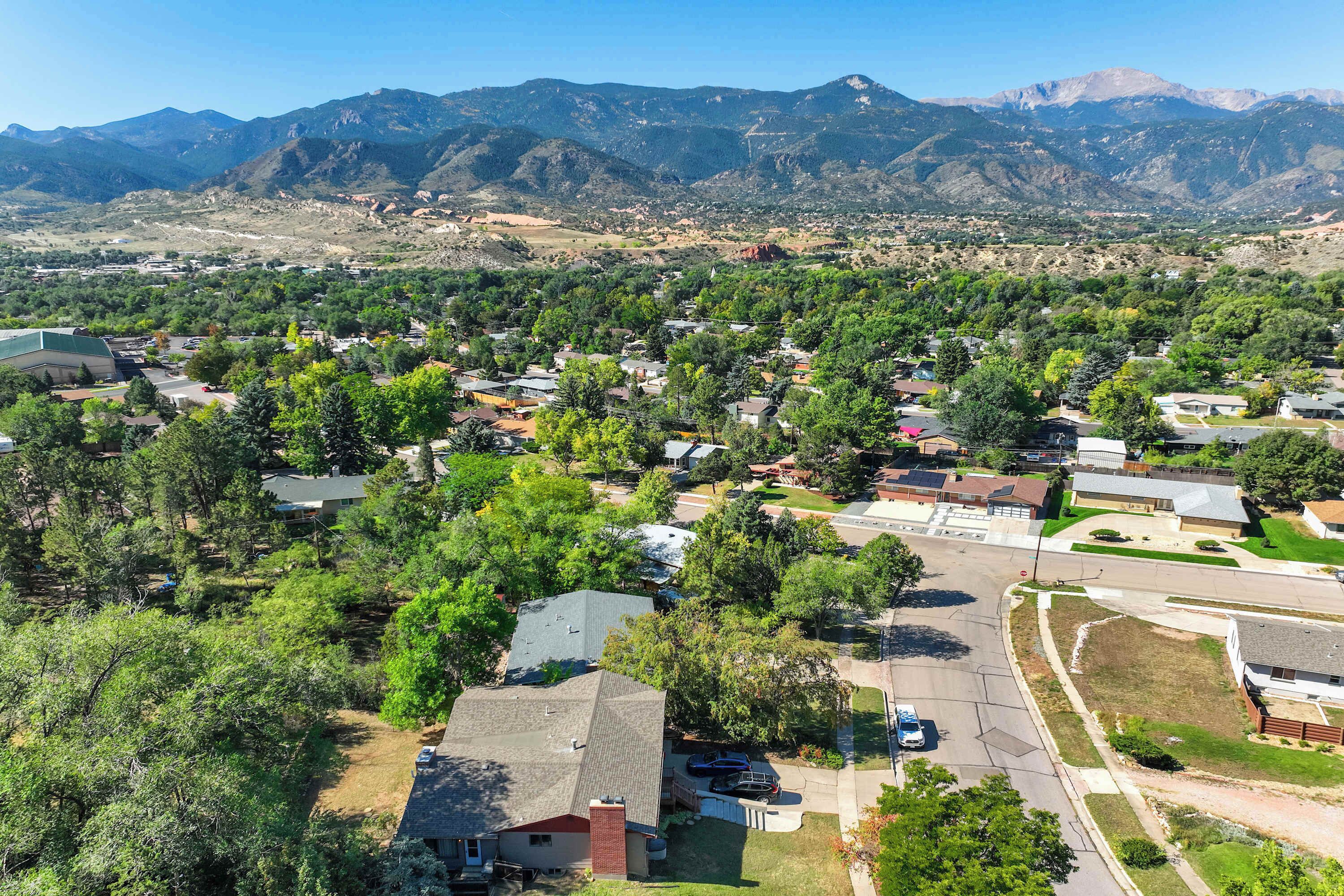 Un quartier résidentiel avec des maisons, des rues et des montagnes en arrière-plan.