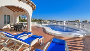 A pool area with lounge chairs and a table, surrounded by a white fence and a clear blue sky. - Wonderful and comfortable villa  with private pool in Benitachell, Costa Blanca, Spain for 6 persons (Benitachell)