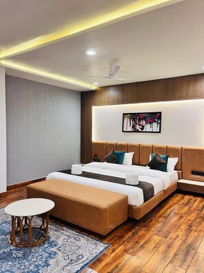 Ein modernes Hotelzimmer mit einem großen Bett, einem Nachttisch, einem kleinen runden Tisch und einem gemusterten Teppich.