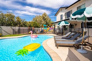 A swimming pool with lounge chairs and a flamingo float.