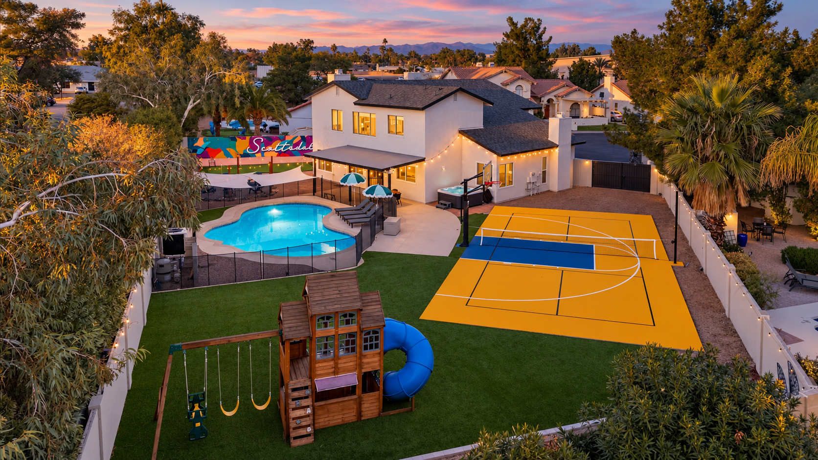 Une propriété résidentielle dotée d’une piscine, d’un terrain de basketball et d’un espace de jeux pour enfants.