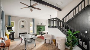 A spacious living room with a pool table, comfortable seating, a staircase, and a view of the outdoors. - Private Pickleball Court, Movie Room, & Hot Tub! (Scottsdale)