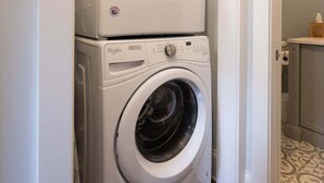 Une petite buanderie équipée d’un lave-linge et d’un sèche-linge superposés.