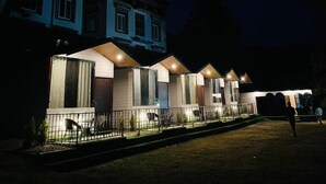 A row of single-story buildings with large windows and a covered outdoor seating area. - The Bluewind Resort (Dehradun)