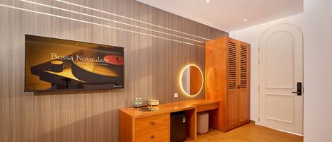 A modern room with a wooden vanity, a television mounted on the wall, and a door with a circular light.
