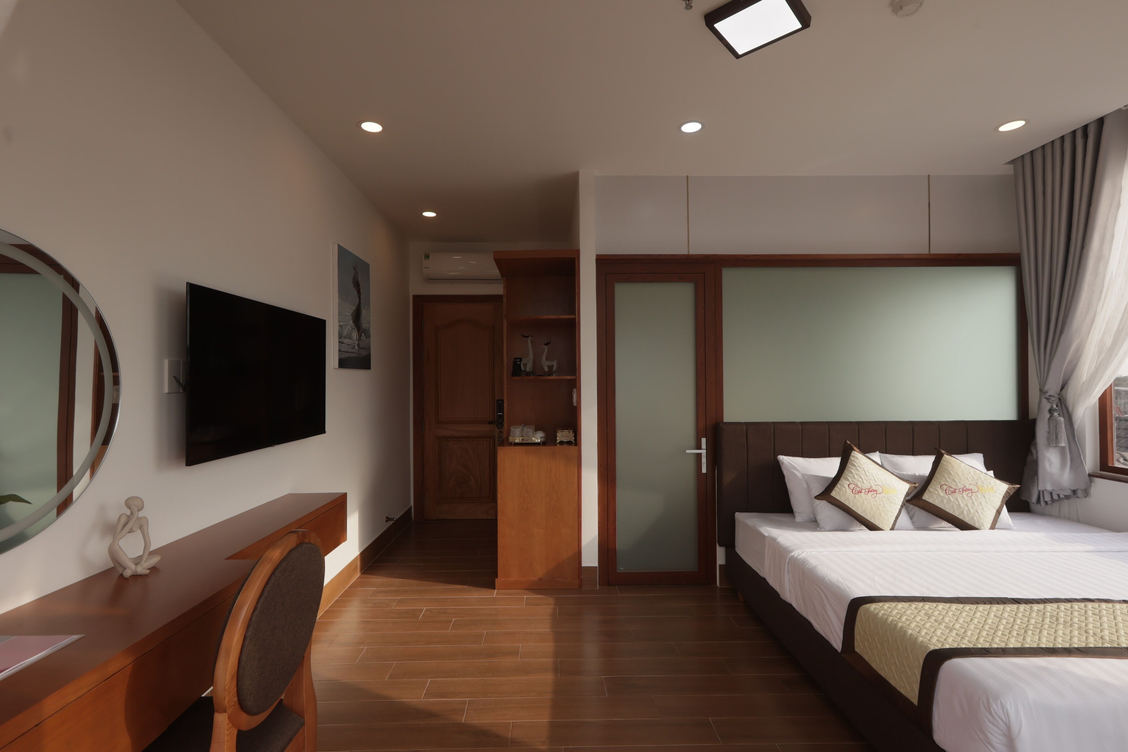 Habitació d'hotel amb llit, escriptori, cadira, televisió i armari.
