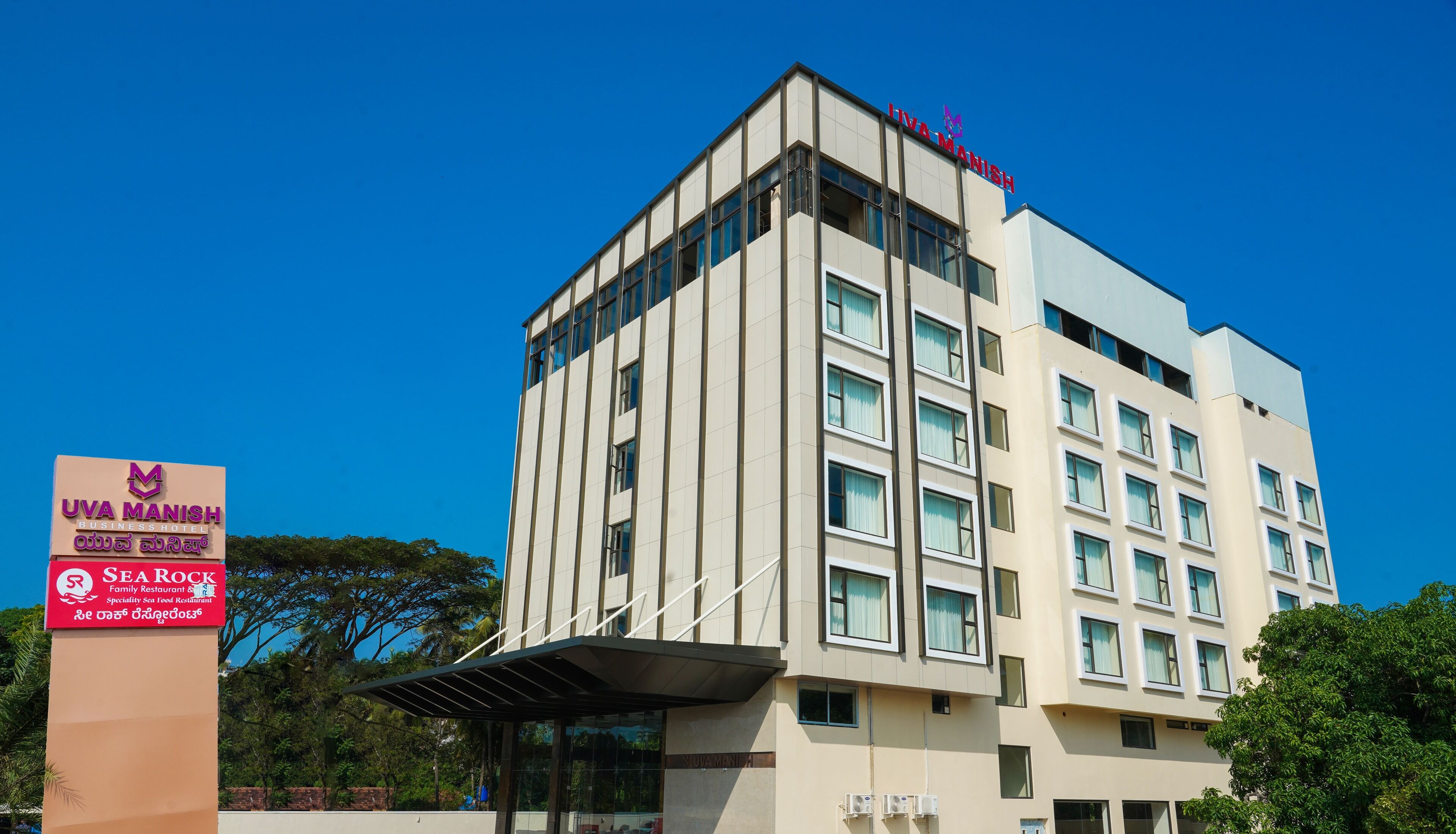 A multi-story hotel with a sign indicating it is the Uva Manish Business Hotel.