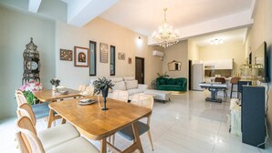 A spacious living area with a dining table, sofas, and a chandelier. - Near River Homestay (Ji'an)