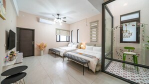A modern bedroom with two beds, a ceiling fan, and a glass partition with a decorative plant. - Near River Homestay (Ji'an)