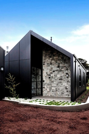 A modern building with a stone facade, a dark exterior, and a clear sky.