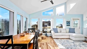A spacious living area with a dining table, a sofa, and a ceiling fan. - Fantastic Rockaway Family Escape – Close to Beach with BBQ (Rockaway Beach)